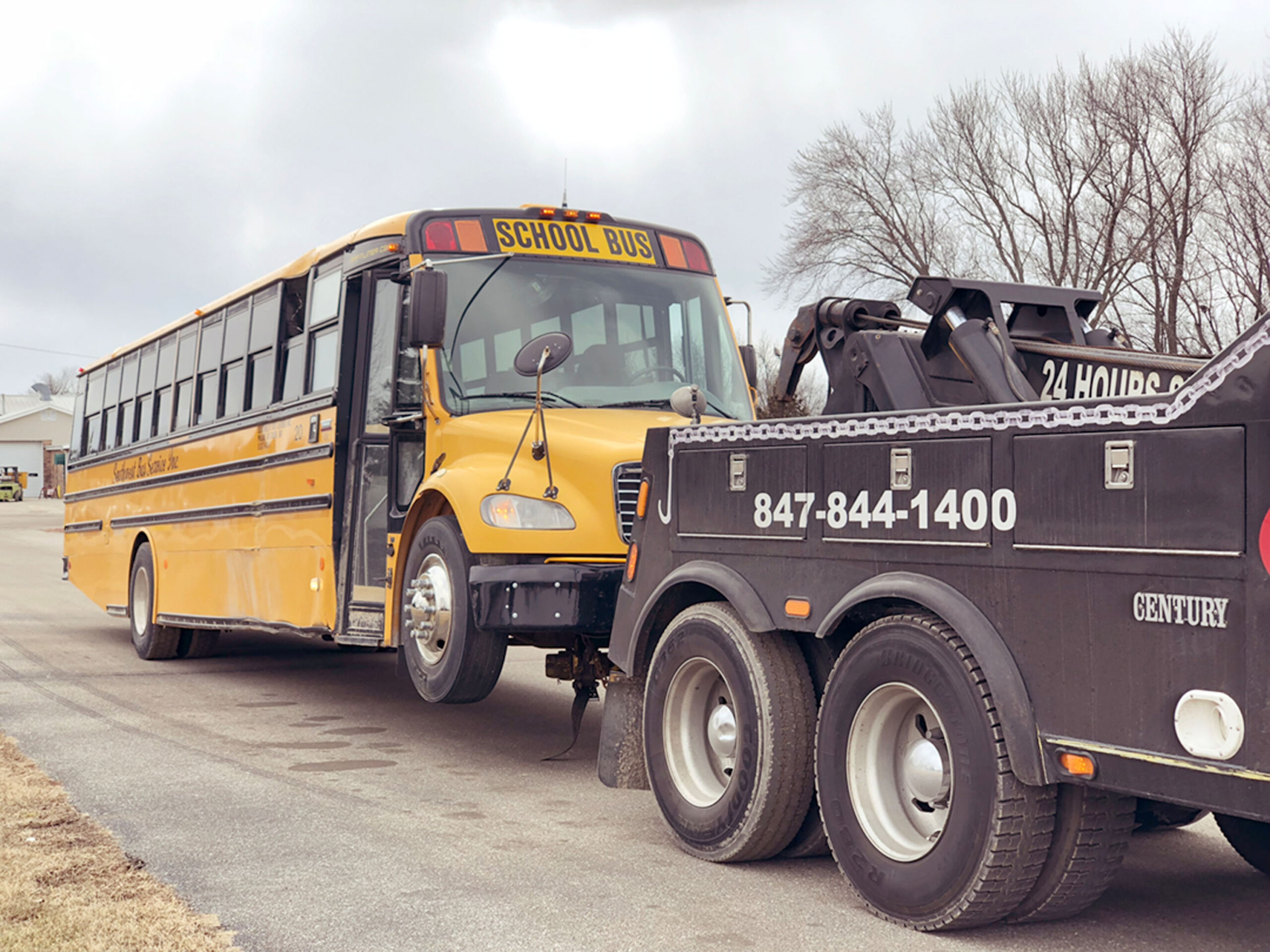Speedy G truck towing a school bus