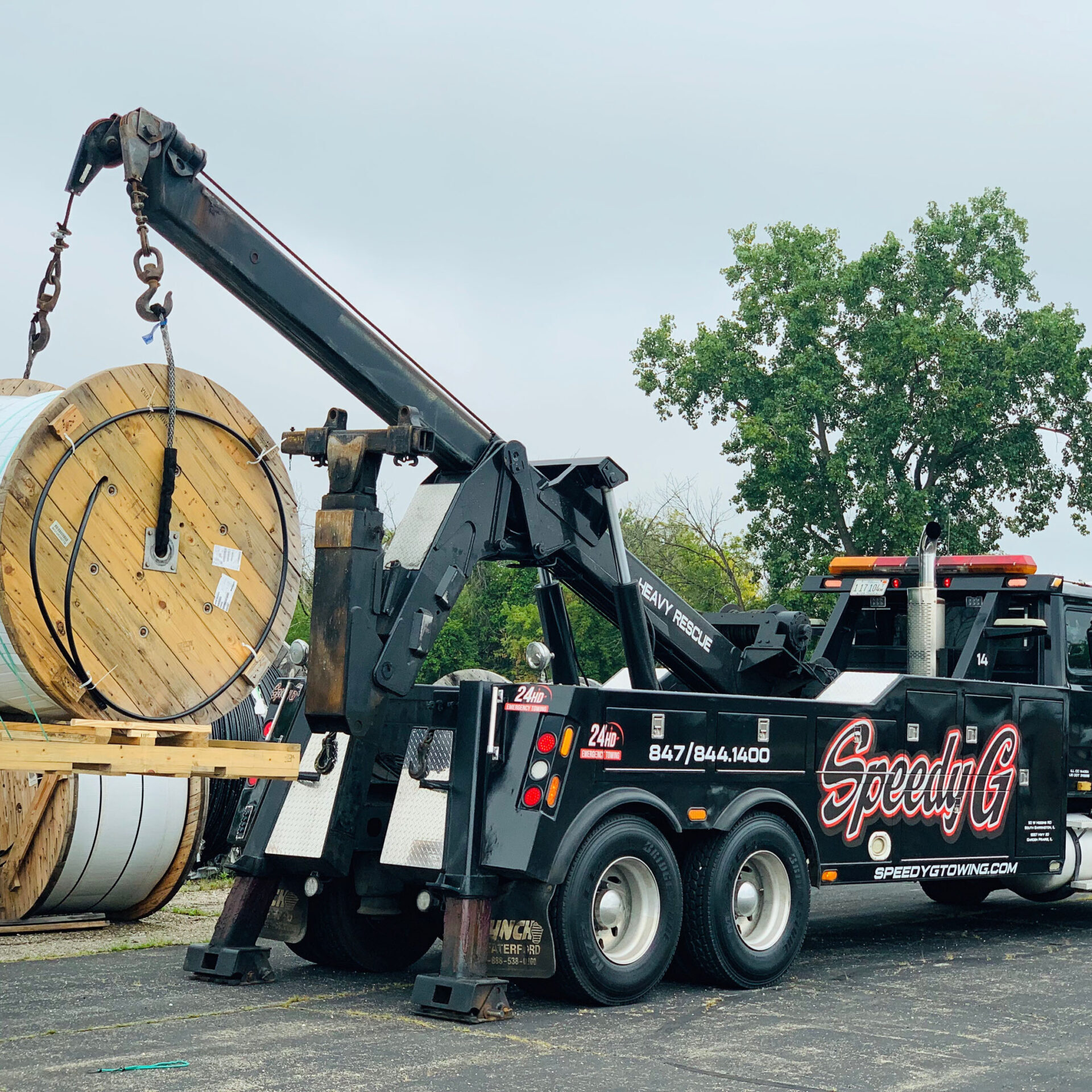 Speedy G truck lifting a large industrial spool of wire
