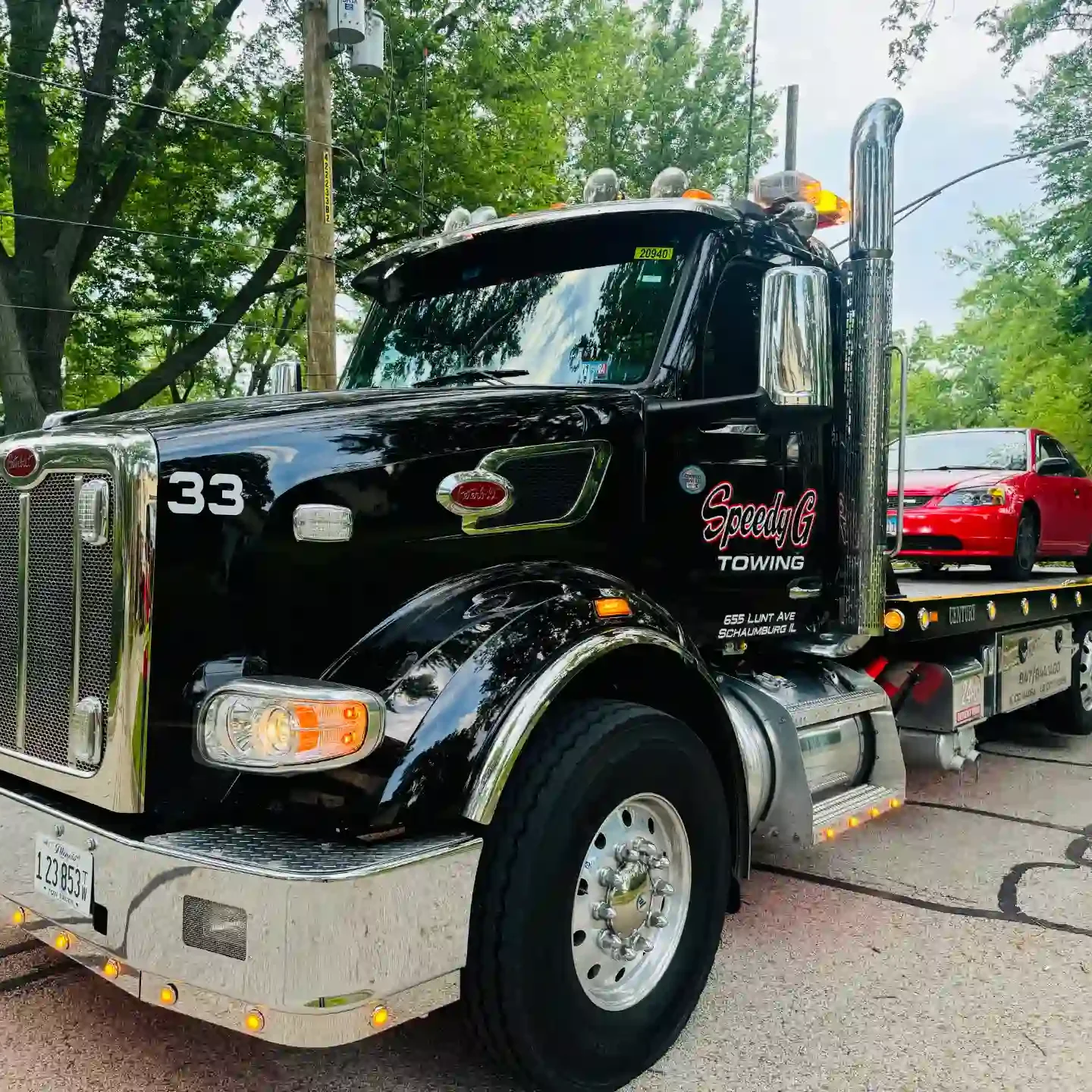 peterbilt-flatbed-tow-truck-hauling-sedan-schaumburg-il