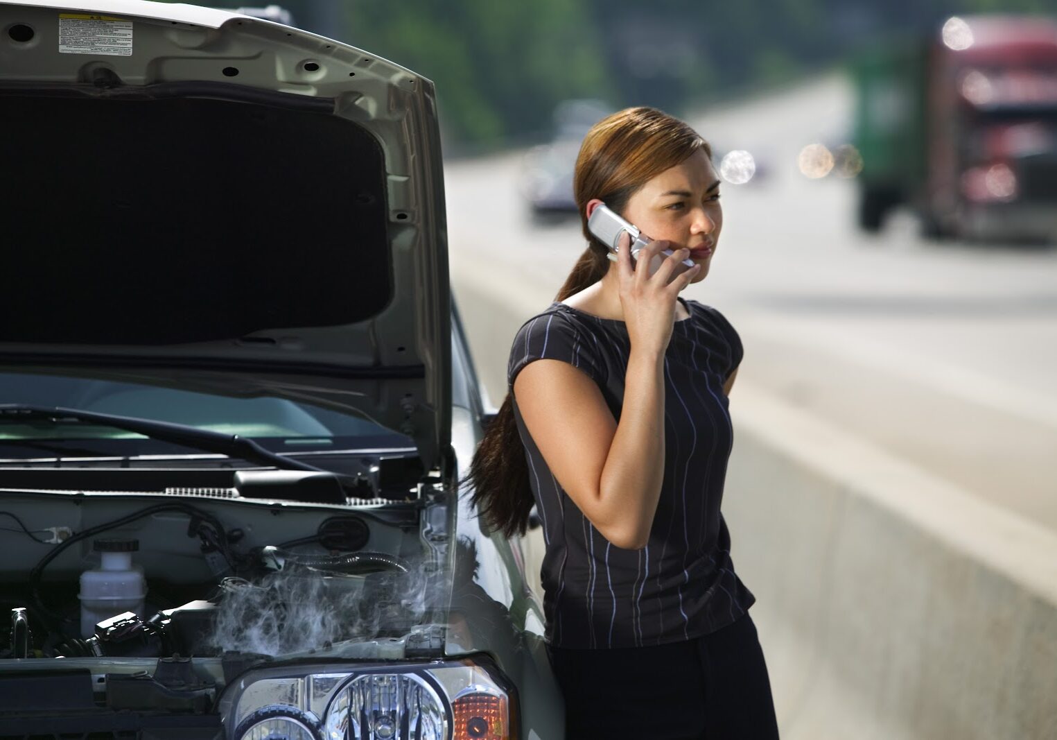 woman-on-side-of-road-with-car-trouble-2290065